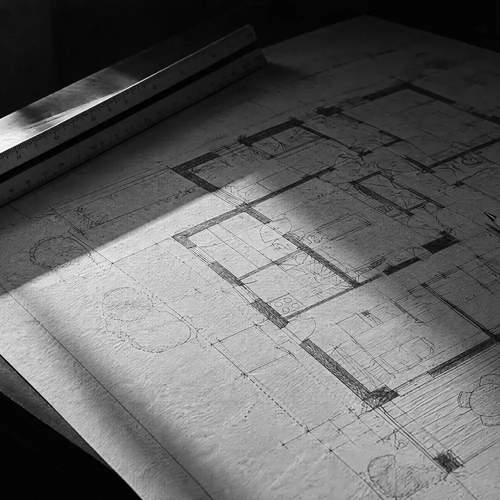 Grundrisszeichnung mit Dreikantmaßstab und Bleistift auf einem Zeichentisch